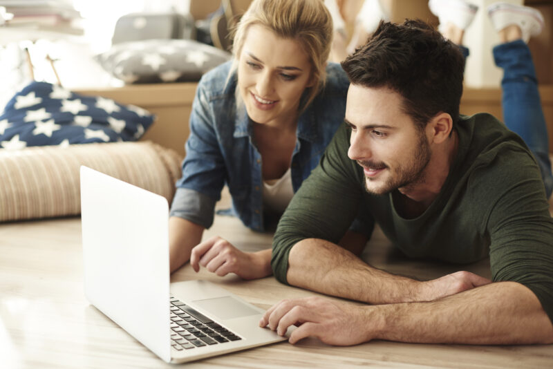 young couple new flat using laptop young couple new flat using laptop